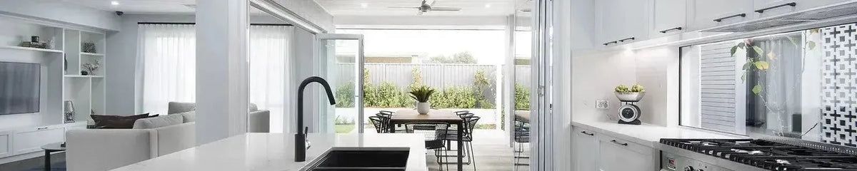 Open plan kitchen and living area featuring white cabinetry and a seamless transition to an outdoor dining space