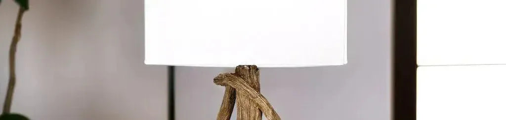 Rustic timber floor lamp with a textured brown branch base and a simple white drum shade in a bright living room