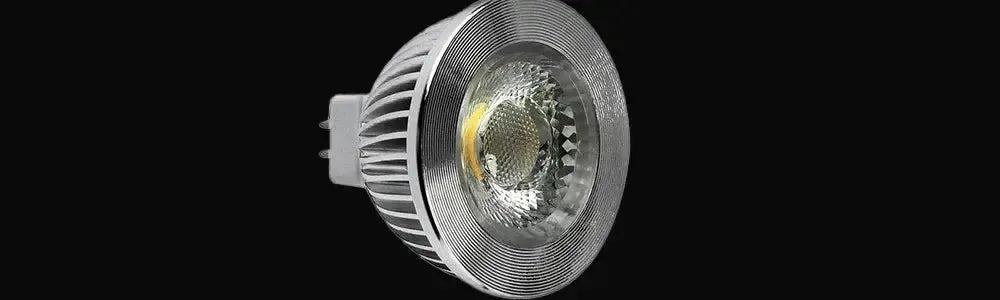 Silver MR16 globe with a ribbed aluminium heat sink body and a faceted glass lens against a black background