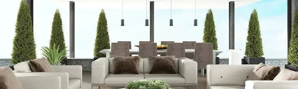 Modern outdoor radiant heaters mounted on a covered patio with cream sofas and manicured topiary trees