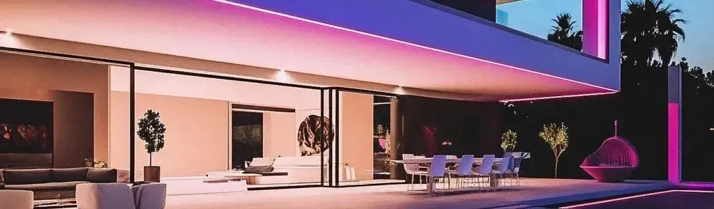 Modern outdoor patio with pink LED strip lighting illuminating a contemporary home exterior at dusk