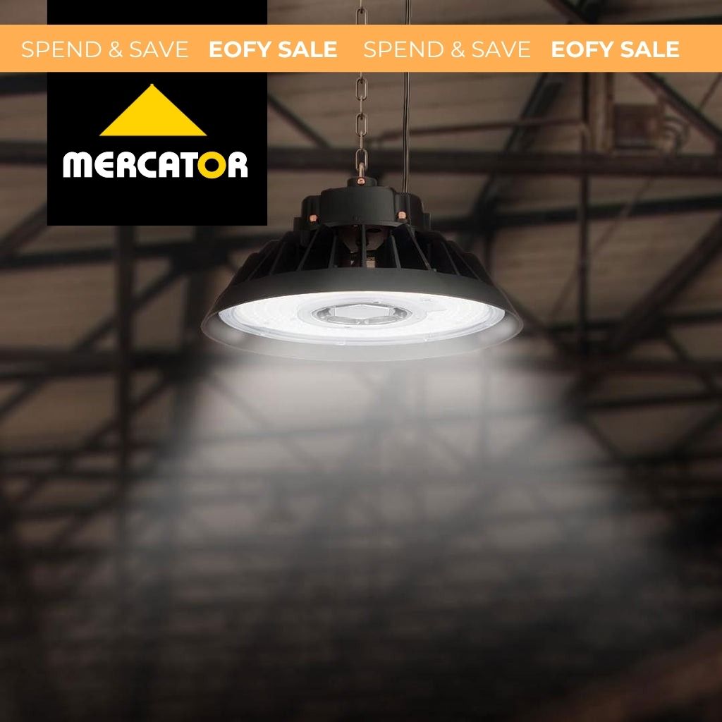 Black industrial pendant light with a ribbed dome shade suspended by a chain in a warehouse setting