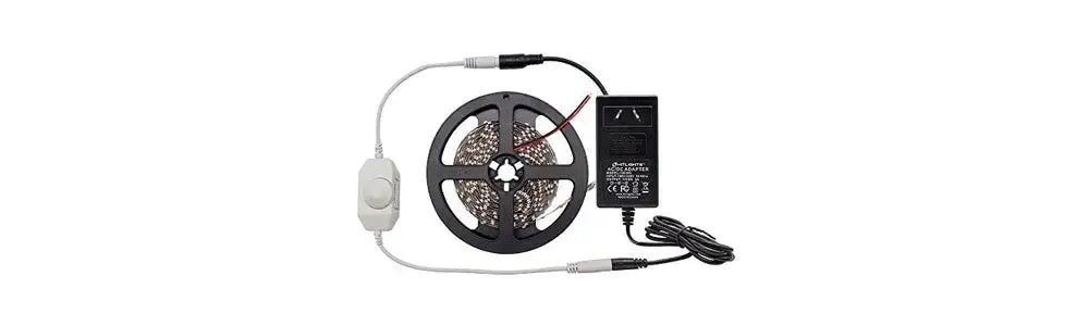 Flexible LED strip light on a black plastic reel with a white inline dimmer switch and a black power adapter
