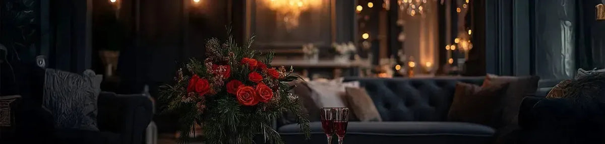 Warm golden light glows in a dark, moody living room featuring a plush velvet sofa and a bouquet of red roses