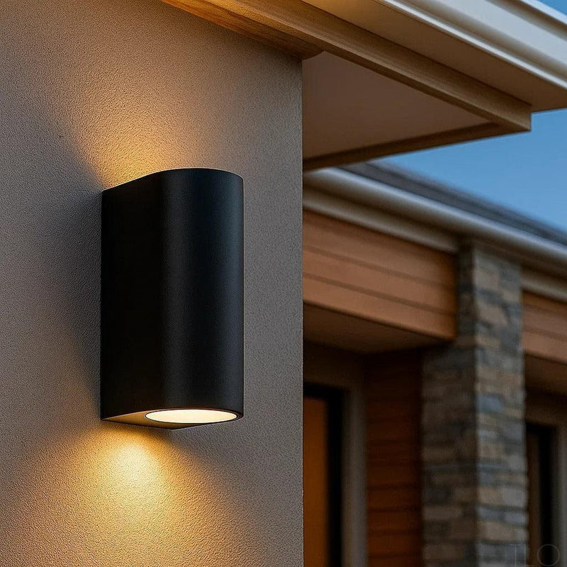 Black Taro outdoor up and down wall light with a rounded aluminium design mounted on an exterior house wall.